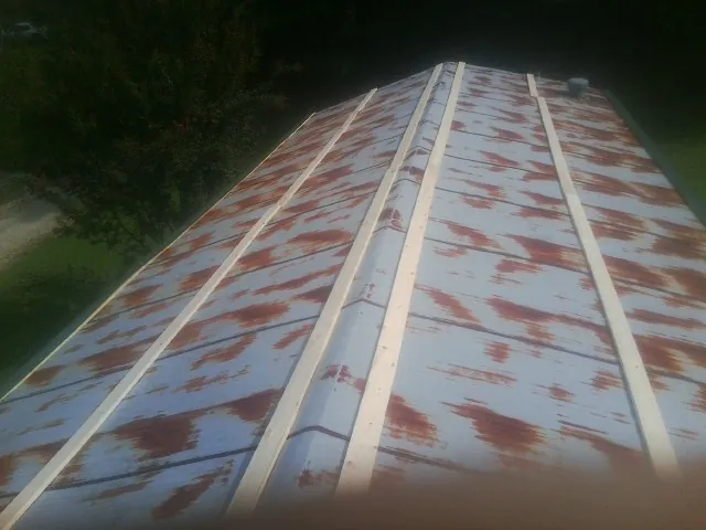 Rusted metal roof panels with new wood purlins before replacement — Storm Damage Roof Repair in New England by Roofing Brothers