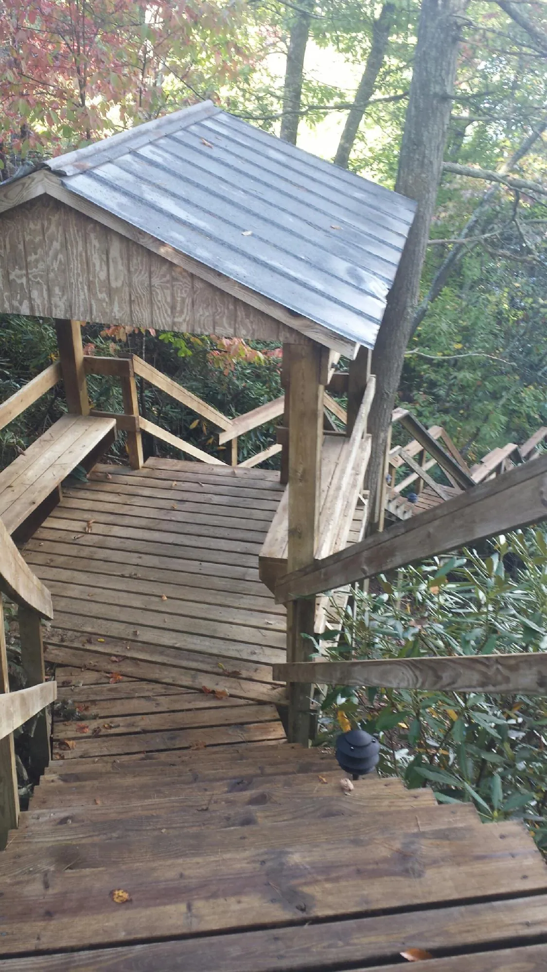 Metal roofed shelter over wooden steps on a wooded walkway — Skylight Repair & Installation work by our crew in New England