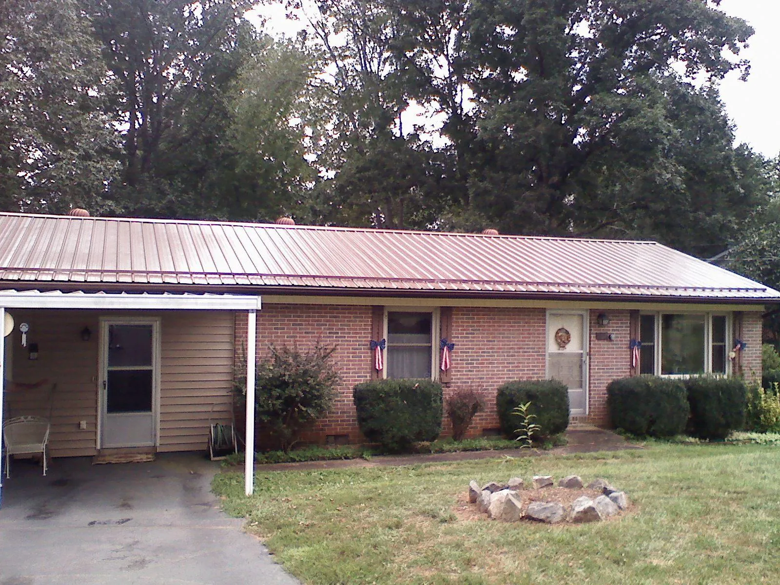 Bronze metal roof and carport on a brick ranch home — Roof Repair work by our crew in New England